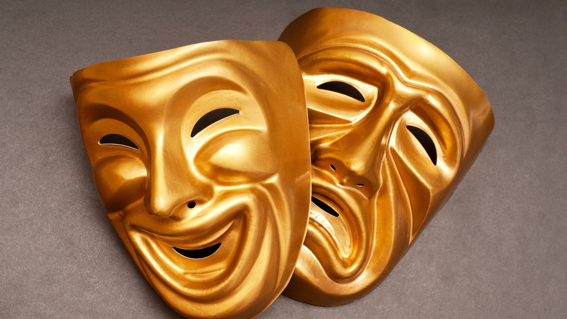 Two gilded theatrical masks — comedy and tragedy — visualising fluent, confident performance that hides what's behind it.